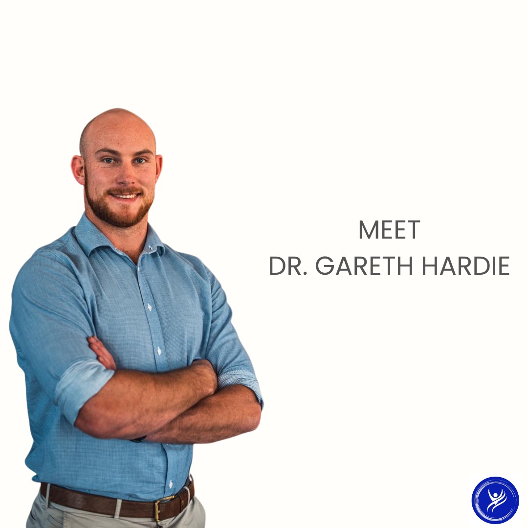 Dr Gareth Hardie standing with arms crossed in a light blue shirt, smiling confidently beside text that reads ‘Meet Dr Gareth Hardie’.
